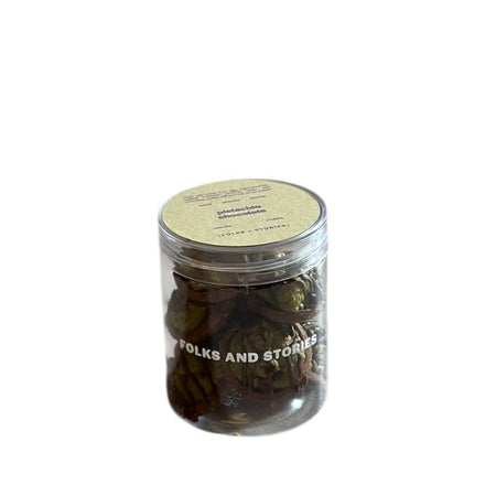 Jar of pistachio kunafa inspired chocolate tartlets with 'Folks and Stories' branding on a white background